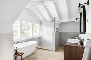 Ensuite bathroom with oval bath, shower and views across Westernport Bay.