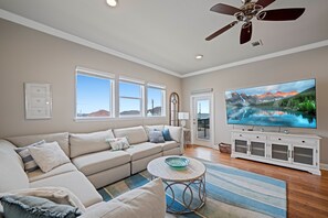 Bright and airy living space featuring plush seating, flat-screen TV, and stunning views of the Gulf right from your couch.