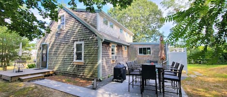 The patio has a table with seating for eight and a gas grill