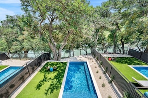 Heated pool with outdoor seating and Comal River views
