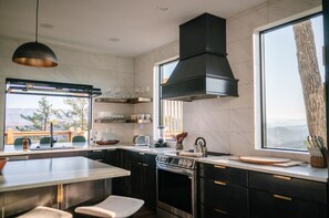 This gourmet kitchen combines elegance and functionality with bold black cabinetry and sleek brass hardware. The oversized island offers plenty of room for cooking and gathering.