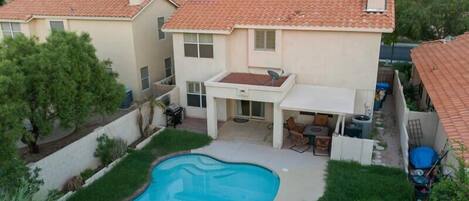 Private backyard with pool, patio seating, bbq and fire table