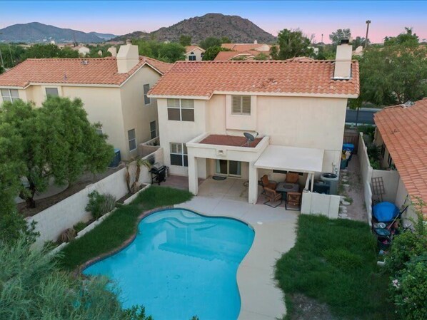 Private backyard with pool, patio seating, bbq and fire table