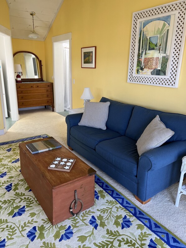 Bright, sunny living room w/pull out couch and sliding doors to deck.