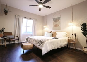 Unwind in a spacious master bedroom with a luxurious king bed, soft lighting, and peaceful vibes.