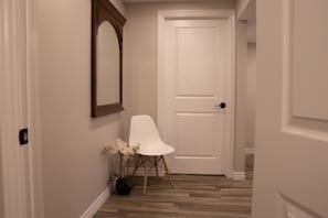 View from bathroom door into hall, washer and dryer behind other door.  