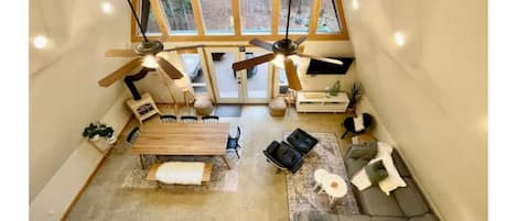 An open concept A-Frame with a beautiful view of the forest. View from the loft.