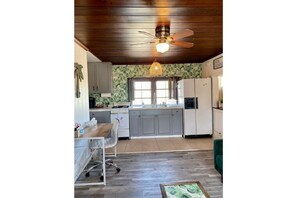 Open concept kitchen has a pass-through window connecting to the dining space.