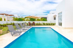 Private back-yard pool with lounge chairs.