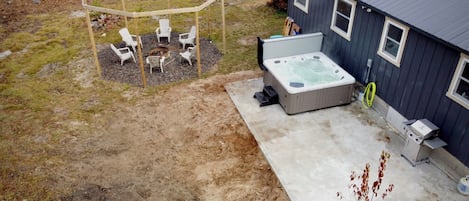 Back yard view of fire put, hot tub, and patio