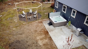 Back yard view of fire put, hot tub, and patio