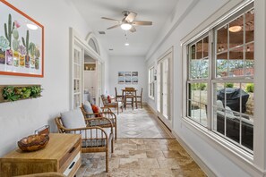 Sunroom off the living room with game table and views to the private backyard.