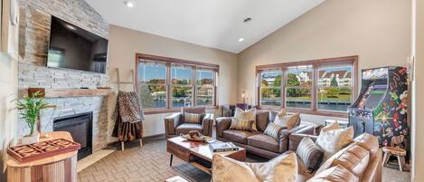 Living room with gas fireplace, streaming television, arcade and great views.