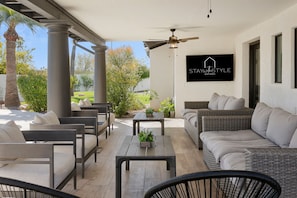 Catch some TV and spread out with this spacious backyard covered patio with lots of seating and TV