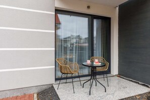 A private patio area featuring a small round table and two chairs, perfect for enjoying morning coffee or evening relaxation.
