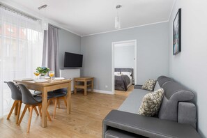 Another perspective of the open-plan living and dining area, showcasing a TV corner and large windows that let in natural light.
