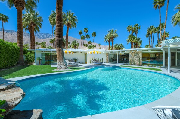 Kidney bean-shaped pool in spacious yard with heaters, misting machines, views. 