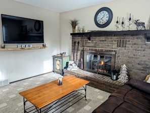 Upper level living room with large natural gas fireplace and smart TV