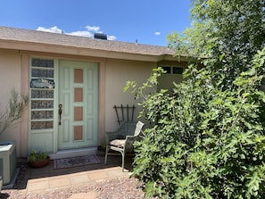 Private entrance with small patio, chair and flowers in pots to welcome you!