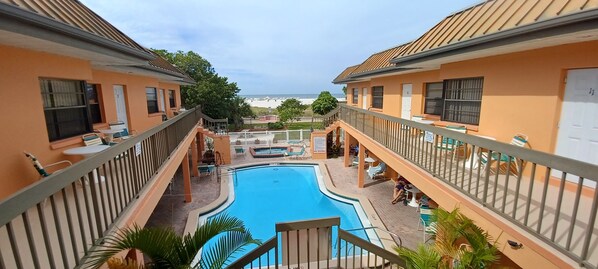 View of pool, hot tub, and the beach