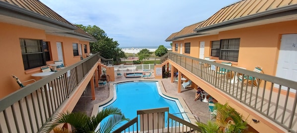 View of pool, hot tub, and the beach