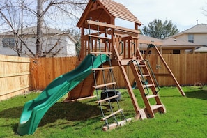 Make unforgettable family memories. Let the kids explore their adventurous side with our exciting outdoor play area, complete with a rock wall, slide, rope ladder, tire swing, fort with a wooden roof, two standard swings, and a trapeze bar.