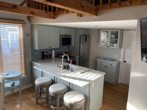 Newly renovated kitchen with quartz counter and seating