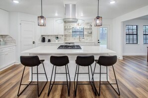 This kitchen’s expansive granite countertops provide ample space for meal prep, while the modern, fully-equipped offerings are designed to inspire your inner chef.