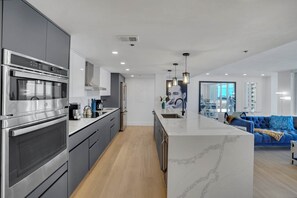 Open concept fully equipped kitchen, Living area with balcony access