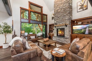 Vaulted Living Room With Stone Gas Fireplace, Timber Beams And Designer Sofa