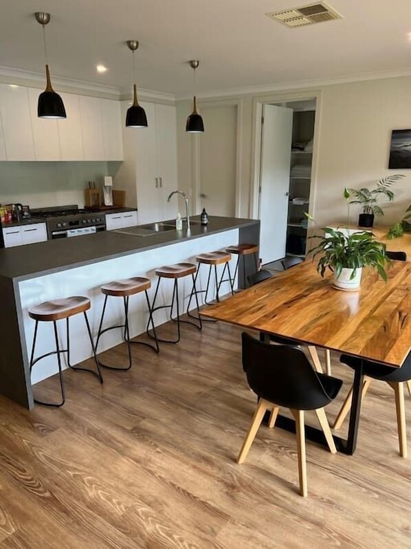 Living / Dining room.  Table seats 6 people comfortably. The table is made from Tasmanian Messmate timber and resin covered to show the shimmering details of the wood grain