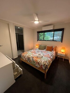 Master bedroom with ensuite door to the left. Double-wide chest of 6 drawers for longer stays, or to place bags on for easy access.
Lamps have warm bulbs for cozy evenings. Aircon unit heats and cools. Blockout blinds can be raised or lowered.