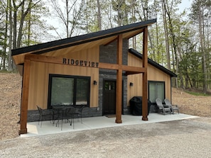 Front view of large patio with table and chairs along with an outdoor grill.