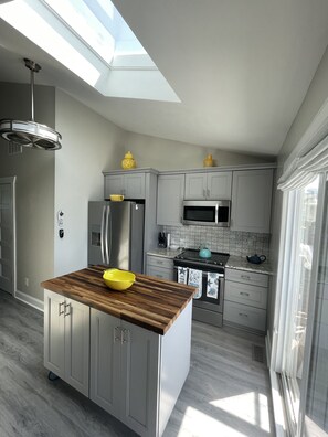 Nicely equipped kitchen includes utensils, pots, plates, etc