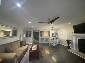 Living area with fireplace, 55” smart TV, and sofa bed. 