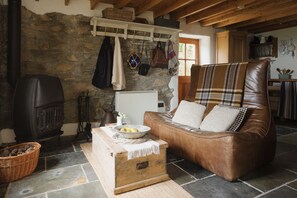 The Studio lounge seating area with TV and vintage wood burner.