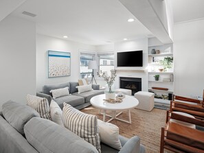 With hues of blues, whites, and natural earthy tones, along with windows that let in abundant natural light, this living room becomes a luminous and calming spot to relax.