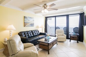 Living Room with A Great View. It Has A Queen Size Leather Sleeper Sofa, 2 Swivel/Rocker Recliners, 3 End Tables, A Coffee Table, A 58" Wall Mounted Smart TV And Balcony Access