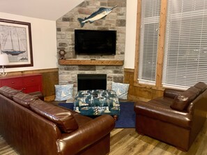 Spacious living room with cozy couches and a lovely fireplace. 