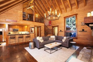 Open concept living room with a large comfy couch, Smart TV, 2 Sonos Speakers, and fireplace! 