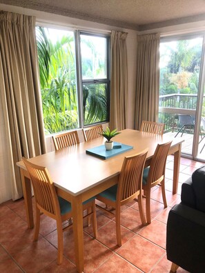 Light, bright dining area, with outdoor vibrant palms 