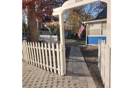 Welcome! Fully fenced yard. With netting behind white pickets for tiny dogs.