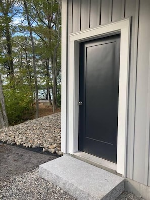 Owl's Nest entry door with a glimpse of the water to the left