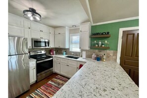 Modern kitchen with white cabinets and granite counters.