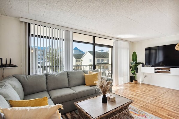 Living Room w/ 75' TV, Sound Bar and Smart Home Speaker