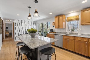 Brand new eat-in kitchen with breakfast bar and granite countertops. 