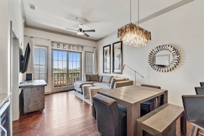 The living room has a large flat screen TV, a sleeper sofa and a private balcony