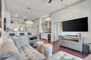 The living room has a large flat screen TV, a sleeper sofa and a private balcony