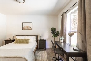 Guest bedroom with desk for easy work from home, USB lamps and queen bed.