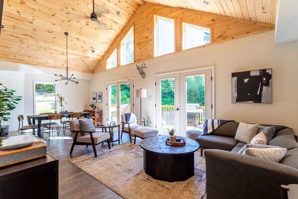 Open floor living room with big windows surrounded by nature